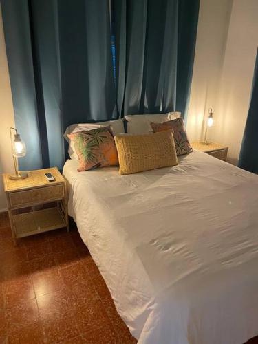 1 dormitorio con cama blanca y cortina azul en Casa Escaleras en Rincón