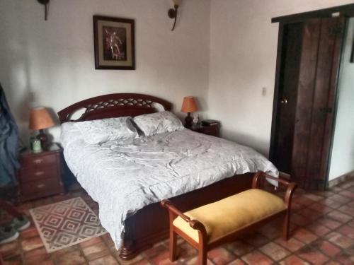 a bedroom with a bed and a chair and two lamps at Villa Rita in Tibasosa