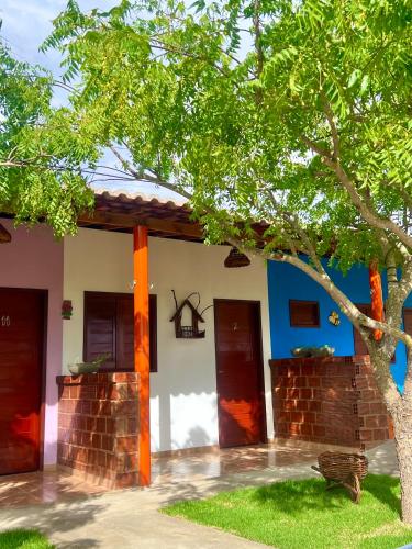 a house with two doors and a tree at Pousada Sonho Meu in Piranhas