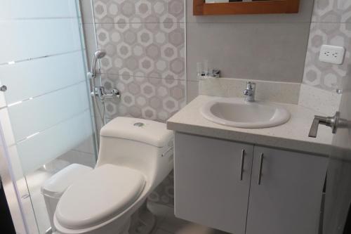 a bathroom with a toilet and a sink at TEYFA Hospedaje - Edificio in Atuntaqui