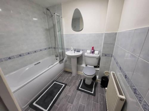 a bathroom with a sink and a toilet and a tub at Modern 2 Bed Apartment - Sleeps up to 5 - Coventry - Business and Leisure Stays in Coventry