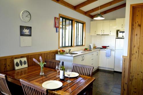 a kitchen with a wooden table with chairs and a dining room at Diamond Forest Farm Stay in Manjimup