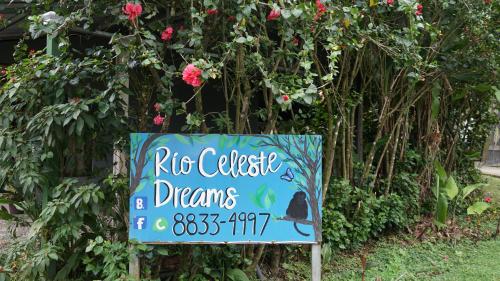 um sinal na frente de um arbusto com rosas em XXX BLUE PARADISE - Rio Celeste Dreams em Bijagua