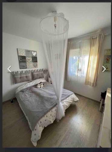 a bedroom with a bed with a mosquito net at maison tout confort in Saint-Vivien-de-Médoc