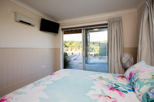 a bedroom with a bed and a large window at Kakatu Retreat Bed & Breakfast in Kaikoura