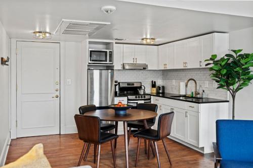 a kitchen with white cabinets and a table and chairs at The Maverick, powered by Placemakr - River Walk in San Antonio
