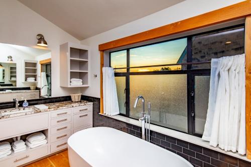 Un baño con una gran ventana y una bañera. en The Gardens of Barons Creek Unit B, en Fredericksburg