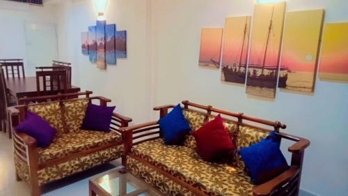 a living room with two couches with colorful pillows at Araliya Uyana Residencies Colombo - Entire House with Two Bedrooms in Colombo