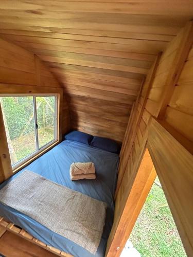 a bed in the middle of a tiny house at Glamping Cabanas do Estaleiro in Balneário Camboriú