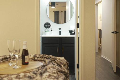 a bathroom with a sink and a mirror and a table at Ashley's Luxurious Snuggery! in Branson