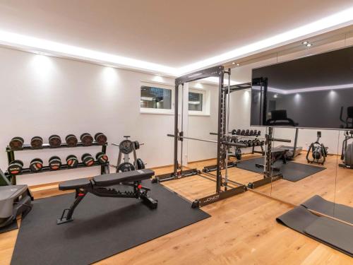 a gym with a lot of exercise equipment and mirrors at Kaminzimmer Suite in Mauterndorf