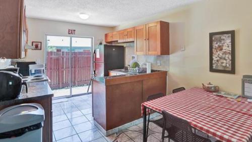a kitchen with a table and a kitchen with a refrigerator at Crocodhouse ,parking ,free coffee in Fort Lauderdale