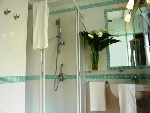 ein Badezimmer mit einer Dusche und einer Vase aus Blumen in der Unterkunft DolceVitaSorrento Guest House in Sorrent