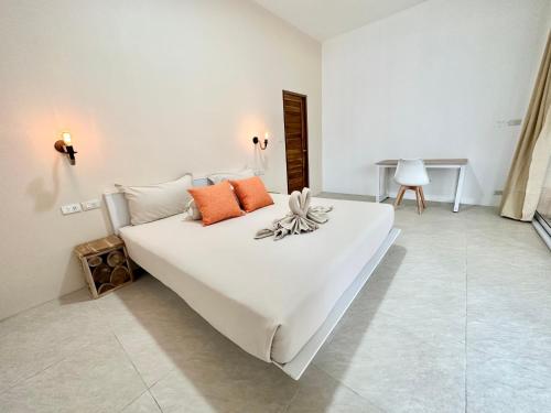 - un lit blanc avec des oreillers orange dans l'établissement Oh'lala luxury pool villas, à Thongsala