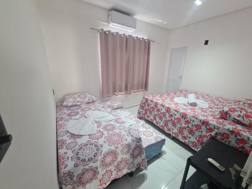 een slaapkamer met twee bedden en een raam bij Casa Mar Aruana in Aracaju