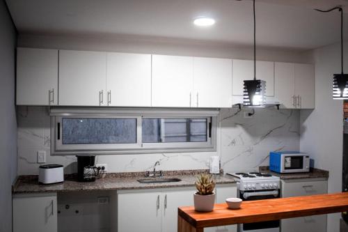 a kitchen with white cabinets and a counter top at un sueño para viajar in Ciudad Lujan de Cuyo