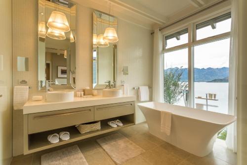 a bathroom with two sinks and a large mirror at Rosewood Matakauri in Queenstown