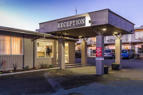a store front with a sign that reads reception at Twin Peaks Lakeside Inn in Taupo