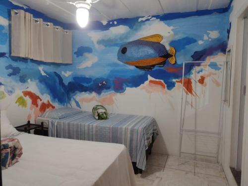 1 dormitorio con un mural de pescado en la pared en Hostel Sandra, en Búzios