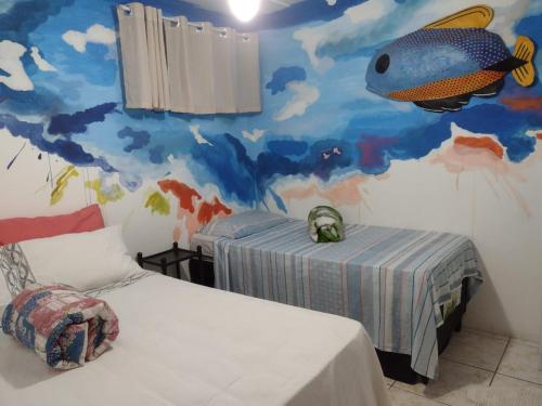 1 dormitorio con un mural de pescado en la pared en Hostel da Dona Sandra, en Búzios