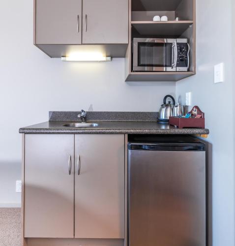 a kitchen with stainless steel cabinets and a sink at Twin Peaks Lakeside Inn in Taupo