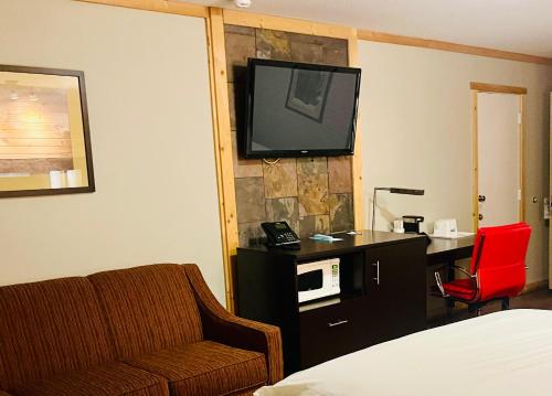 a hotel room with a couch and a tv on the wall at Americas Best Value Inn Wall in Wall