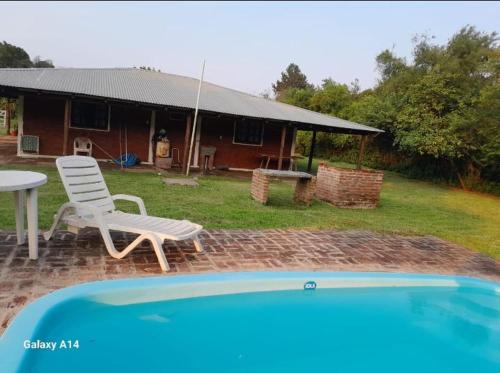 un patio con una mesa y una silla y una casa en Cabaña Iberá en Colonia Carlos Pellegrini