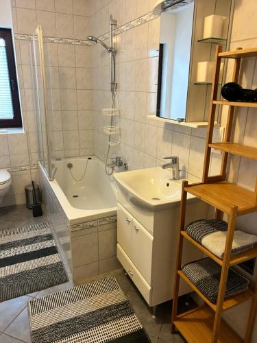 ein Badezimmer mit einem Waschbecken, einer Badewanne und einem WC in der Unterkunft Kraewelhof in Schrozberg