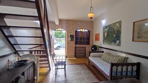 a living room with a couch and a staircase at Casa da felicidade praia do forte 2 quartos in Itaparica