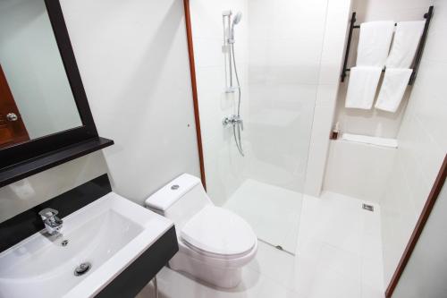 a bathroom with a toilet and a shower and a sink at Tai-Shan Suites in Ratchaburi