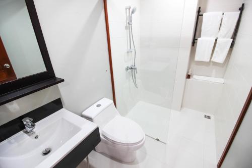a bathroom with a toilet and a shower and a sink at Tai-Shan Suites in Ratchaburi