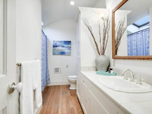 a white bathroom with a sink and a toilet at Gardens of Baron's Creek - Unit D in Fredericksburg