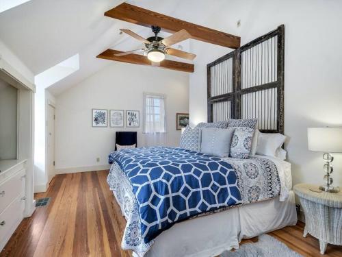 a bedroom with a bed and a ceiling fan at Gardens of Baron's Creek - Unit D in Fredericksburg