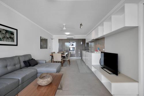 a living room with a couch and a tv at Stunning 2 Bedroom Self Contained City Apartment in Mackay