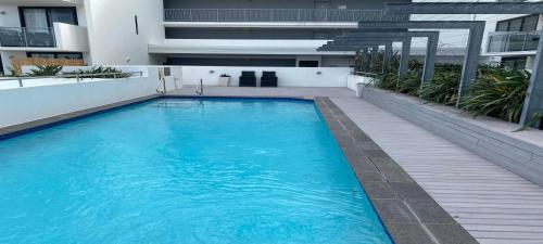 a large blue swimming pool on the side of a building at Stunning 2 Bedroom Self Contained City Apartment in Mackay