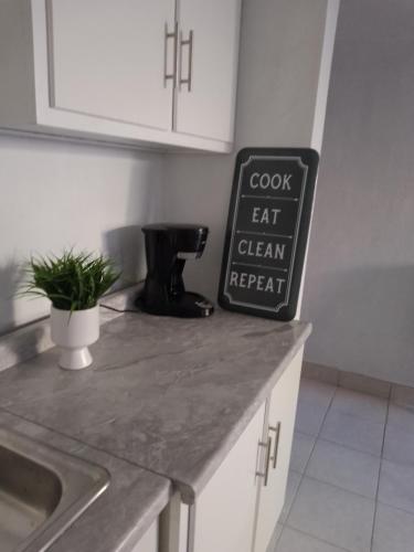 a kitchen counter with a cook eat clean repeat sign on it at Departamento por dia in Nuevo Casas Grandes