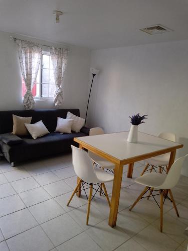 - un salon avec une table, des chaises et un canapé dans l'établissement Departamento por dia, à Nuevo Casas Grandes