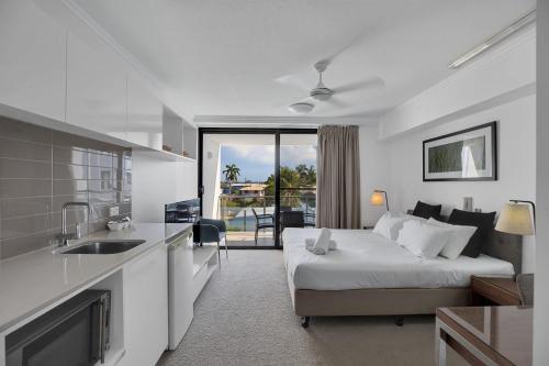 a bedroom with a bed and a kitchen with a sink at Self Check in Modern Studio Apartment in Mackay