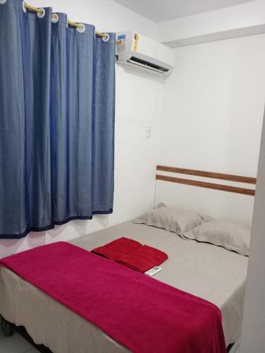 a bedroom with a bed with blue and purple curtains at Apartamento 1 km da praia do aracagir confortavel in São José de Ribamar