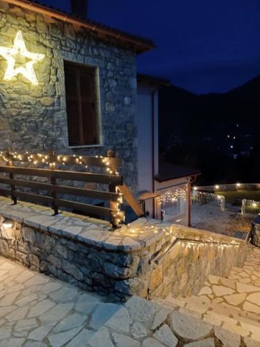 a stone building with a bench with lights on it at Anastasia's Suites Arcadia in Vytina