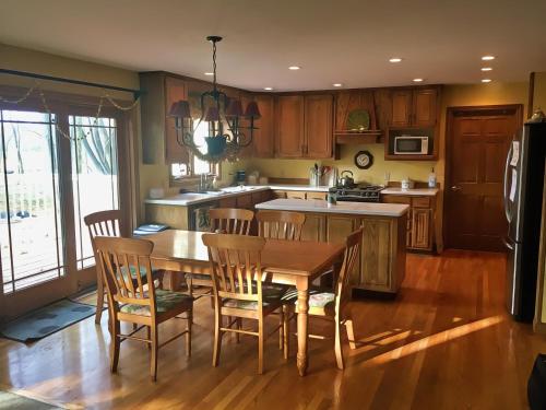 a kitchen with a wooden table and wooden chairs at North Oaks Estate in Blaine