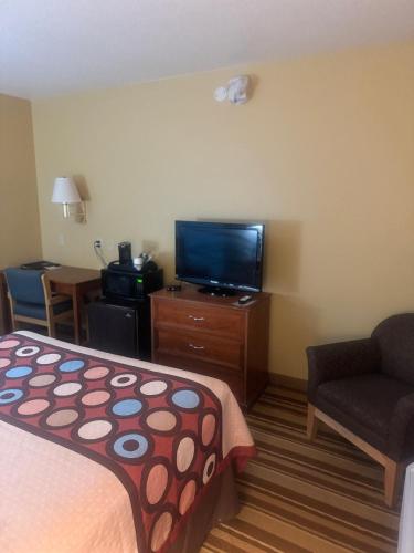 a hotel room with a bed and a flat screen tv at Super 8 by Wyndham Sparta in Sparta