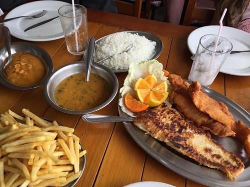 a table with a plate of food and french fries at Suìte Madagascar in Penha