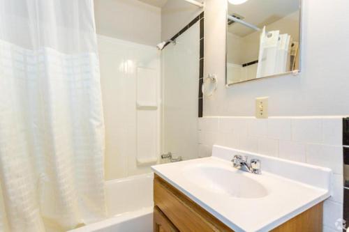 y baño blanco con lavabo y ducha. en Anchor Bay Inn By OYO Reedsport, en Reedsport