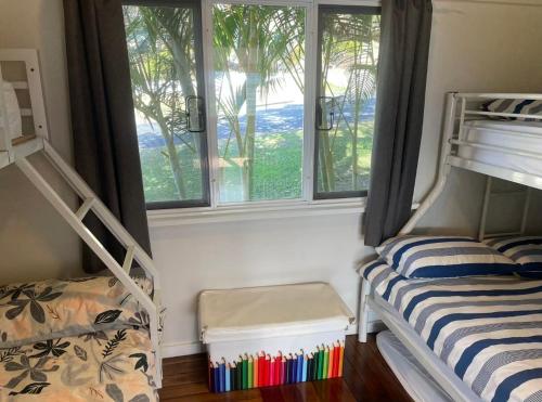 a bedroom with two bunk beds and a window at Good Vibes, 18 East Street in Crescent Head