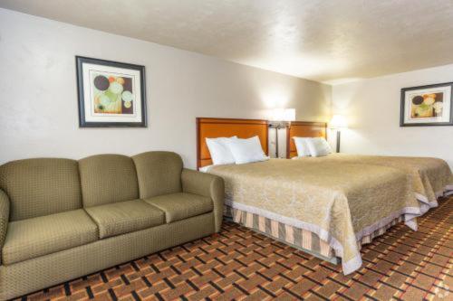 um quarto de hotel com uma cama e um sofá em Anchor Bay Inn By OYO Reedsport em Reedsport