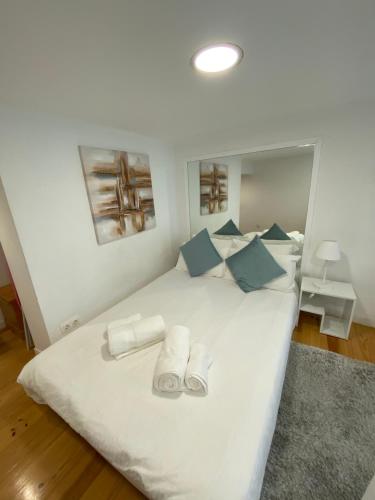 Elle comprend un grand lit blanc avec des oreillers bleus. dans l'établissement Charm of Lisbon II, à Lisbonne