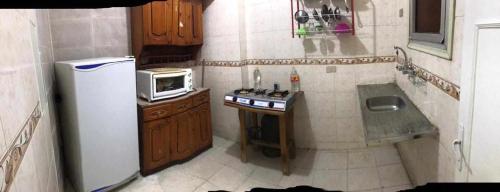 una pequeña cocina con nevera y microondas en Buba apartment, 