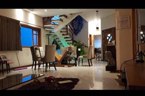 a living room with a staircase and a table and chairs at Casa tranquila parece interior bem localizada. in Osasco