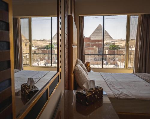 een kamer met een bed en uitzicht op de piramides bij Sphinx golden gate pyramids view in Caïro
